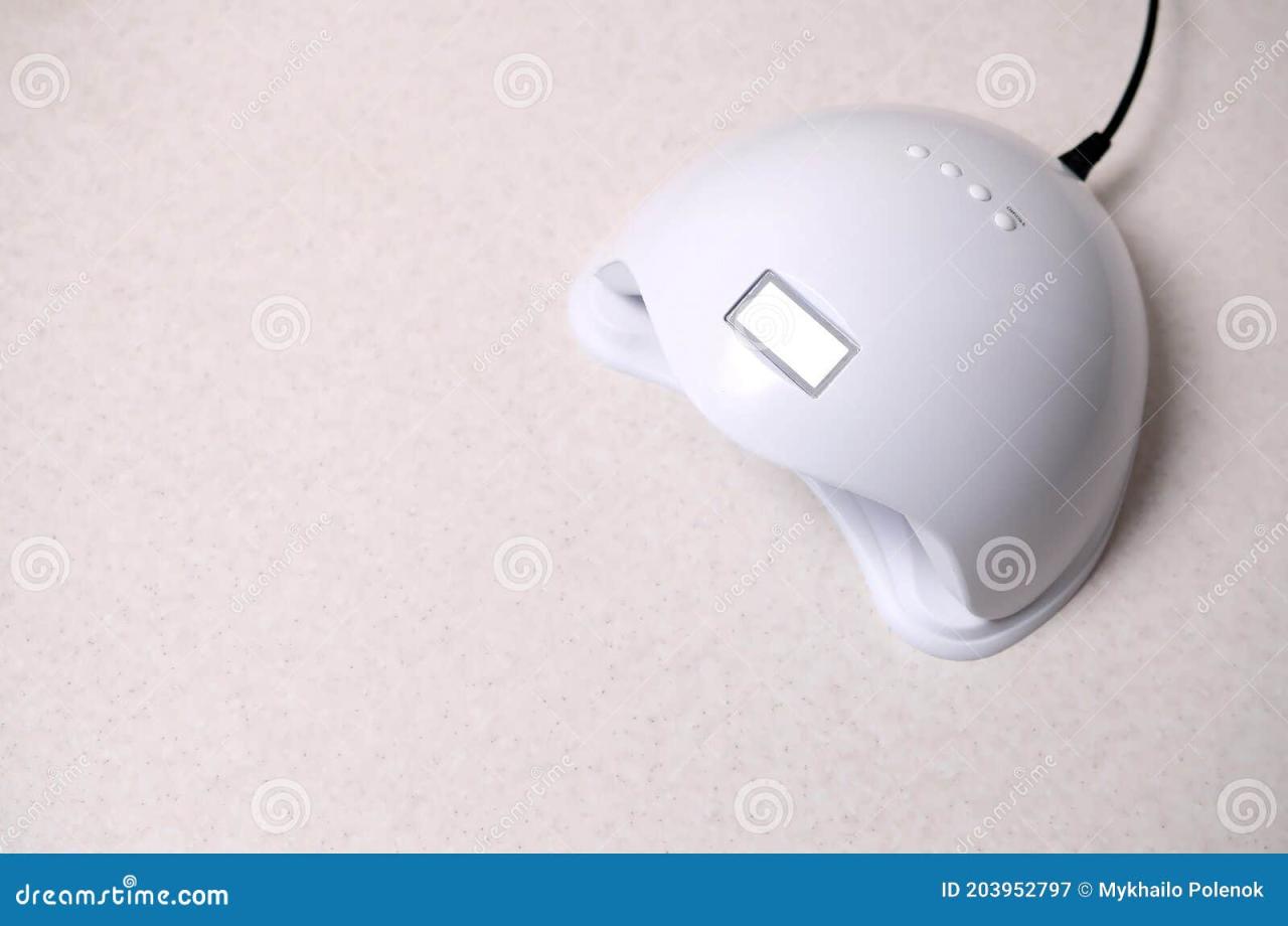 UV LED Nail Lamp for Curing Process by Gel Method Lies on White Table ...